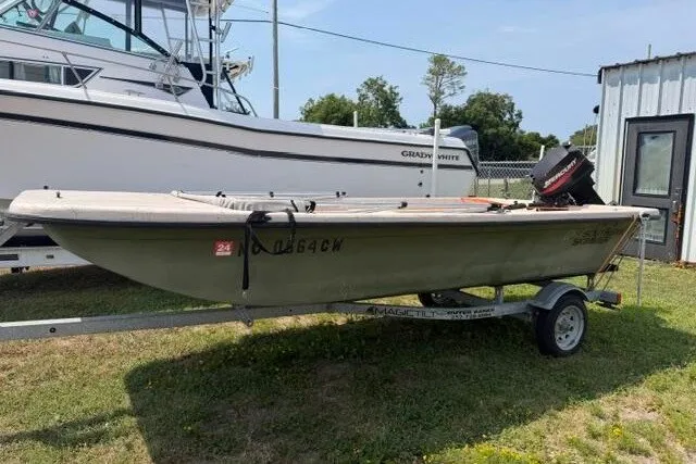 The Image of 2003 Southern Skimmer 14 SKIFF boat on trailer, parked outdoors near other boats. - 1