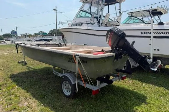 Slide: The Image of 2003 Southern Skimmer 14 Skiff boat on trailer with outboard motor, parked on grass. - 8