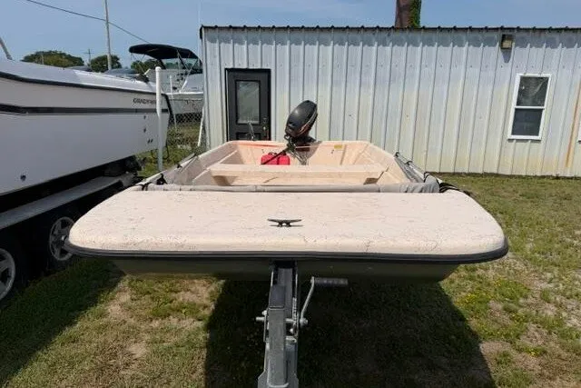 Slide: The Image of 2003 Southern Skimmer 14 SKIFF boat on trailer, parked outdoors near a building. - 2