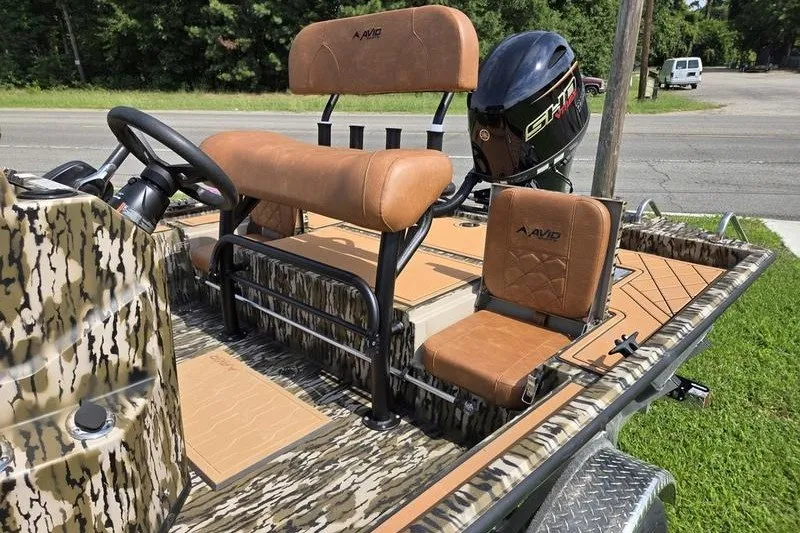 Slide: The Image of 2027 Avid 20 Rogue CC boat with camo design and tan seating. - 13