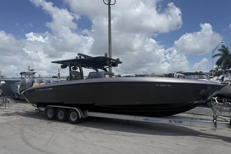 The Image of 2007 Midnight Express 37 Open boat on trailer under cloudy sky. - 1