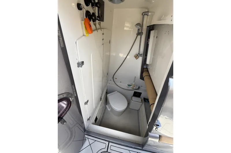 Slide: The Image of Compact bathroom in a 2007 Midnight Express 37 Open boat, featuring a toilet and shower. - 29