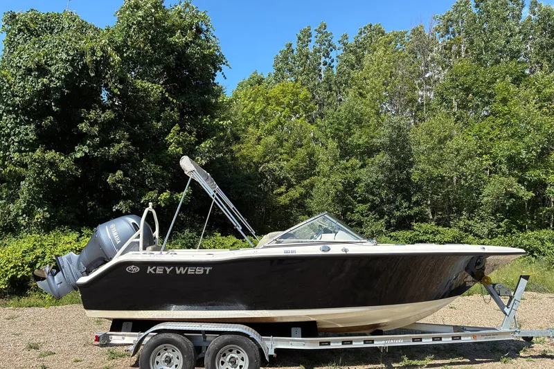 The Image of 2023 Key West 203 DFS boat on trailer, surrounded by lush greenery. - 0