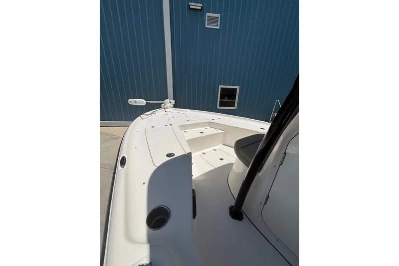 Slide: The Image of 2023 Key West 239 FS boat interior with seating and storage, docked near a blue wall. - 8