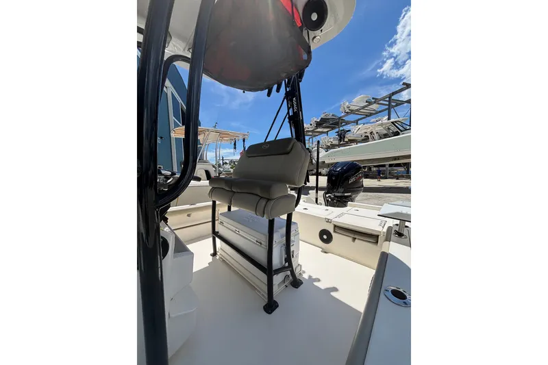 Slide: The Image of 2023 Key West 239 FS boat interior with seating and storage, docked under a clear blue sky. - 7