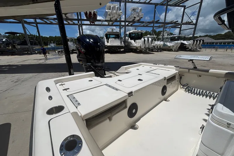 Slide: The Image of 2023 Key West 239 FS boat interior with motor, docked at marina under clear sky. - 12