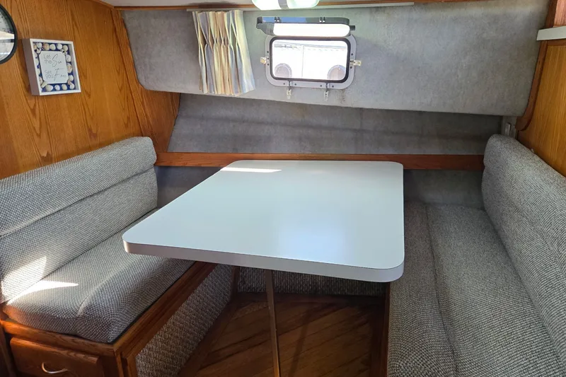 Slide: The Image of 1988 Mainship 36 Double Cabin interior with cozy dining area and window view. - 7