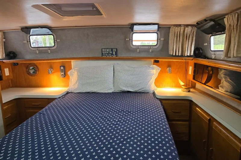 Slide: The Image of Cozy cabin bedroom in 1988 Mainship 36 Double Cabin with nautical decor and ambient lighting. - 8