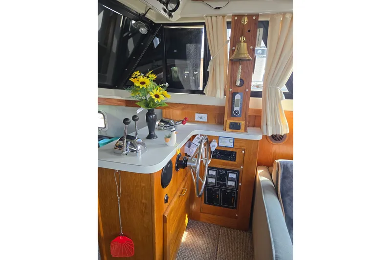 Slide: The Image of 1988 Mainship 36 Double Cabin helm with controls, flowers, and nautical decor. - 12