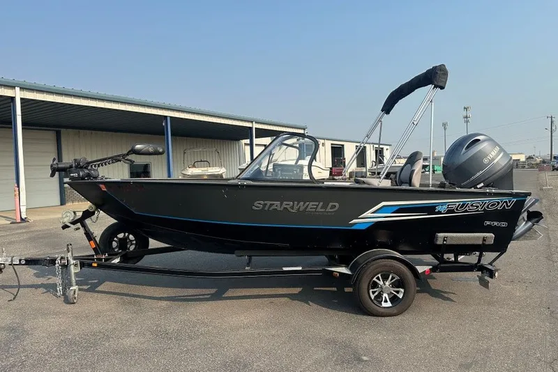 Slide: The Image of 2021 Starweld Fusion 16 DC boat on trailer, parked outdoors. - 1
