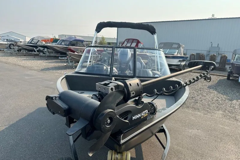 Slide: The Image of 2021 Starweld Fusion 16 DC boat with Minn Kota trolling motor in a marina. - 2