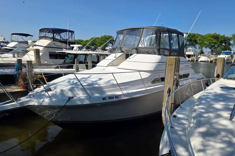 The Image of 1996 Carver 380 Santego yacht docked at marina under clear blue sky. - 1