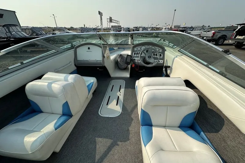 Slide: The Image of 1994 Reinell 184 boat interior with white and blue seating, dashboard, and steering wheel. - 4