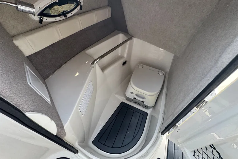 Slide: The Image of Interior of the 2022 Stingray 214 LR featuring a small toilet and gray walls. - 16