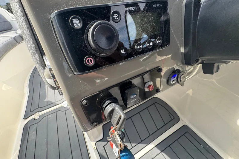 Slide: The Image of Control panel of a 2022 Stingray 214 LR boat with audio system and ignition key. - 9