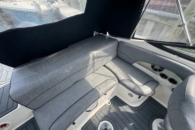 Slide: The Image of 2022 Stingray 214 LR boat interior with gray seating and cup holders. - 13