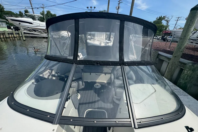Slide: The Image of 2022 Stingray 214 LR boat with clear canopy, docked near water. - 22