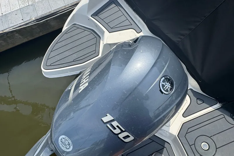 Slide: The Image of 2022 Stingray 214 LR boat with Yamaha 150 outboard engine at dock. - 2