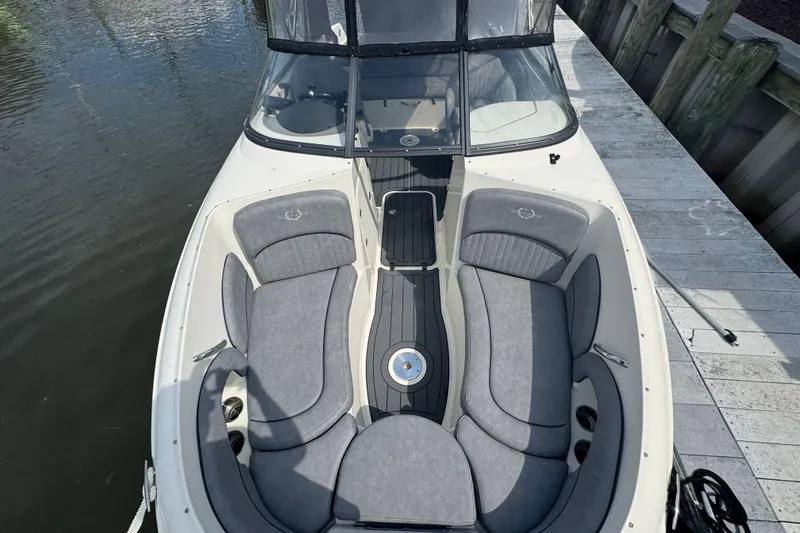 Slide: The Image of 2022 Stingray 214 LR boat with gray seating, docked by the water. - 21