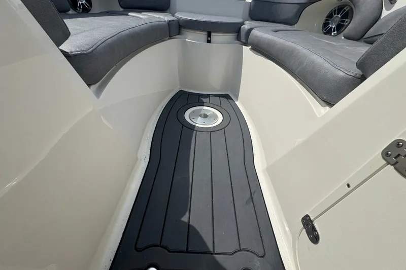 Slide: The Image of 2022 Stingray 214 LR boat interior with cushioned seating and sleek flooring. - 18