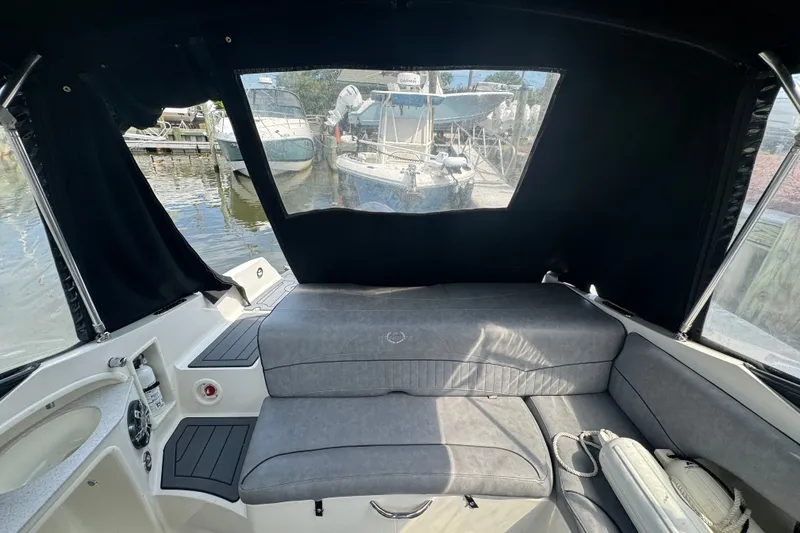 Slide: The Image of 2022 Stingray 214 LR boat interior with cushioned seating and covered canopy. - 6