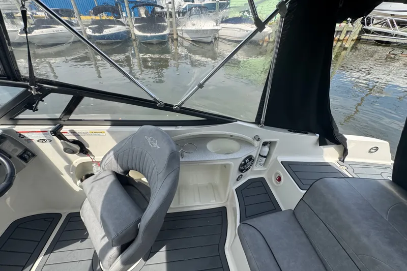 Slide: The Image of Interior of a 2022 Stingray 214 LR boat with seating and control panel. - 7