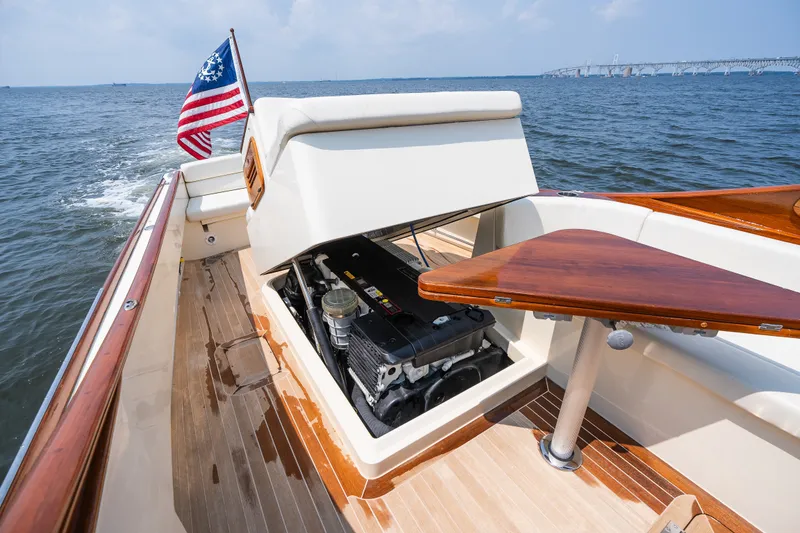 Slide: The Image of 2008 Hinckley Talaria 29R boat with open engine compartment, wooden deck, and American flag. - 43