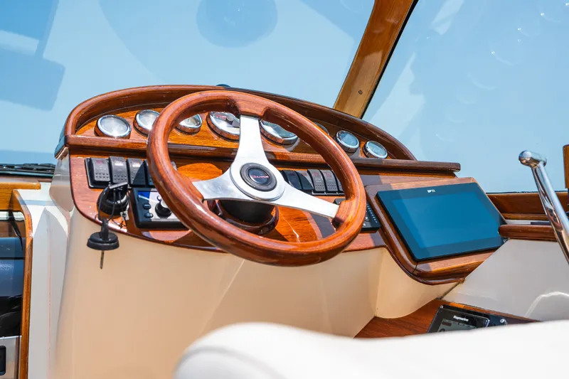 Slide: The Image of Helm of 2008 Hinckley Talaria 29R with wooden steering wheel and modern controls. - 23