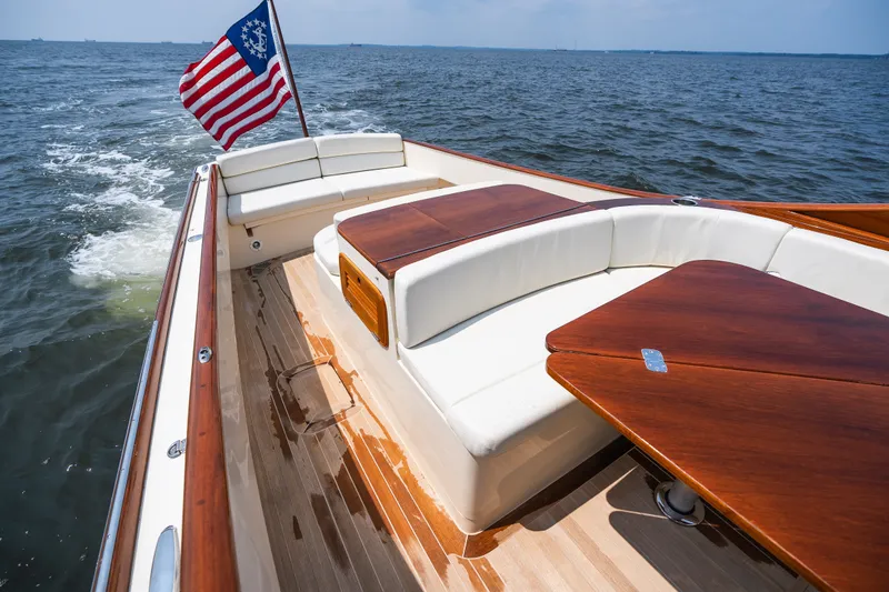Slide: The Image of 2008 Hinckley Talaria 29R boat with wooden deck and American flag on open water. - 37