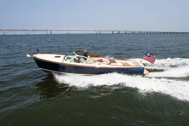Slide: The Image of 2008 Hinckley Talaria 29R cruising on open water with bridge in background. - 6