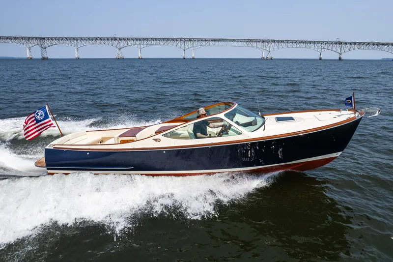 Slide: The Image of 2008 Hinckley Talaria 29R cruising on water with bridge in background. - 10
