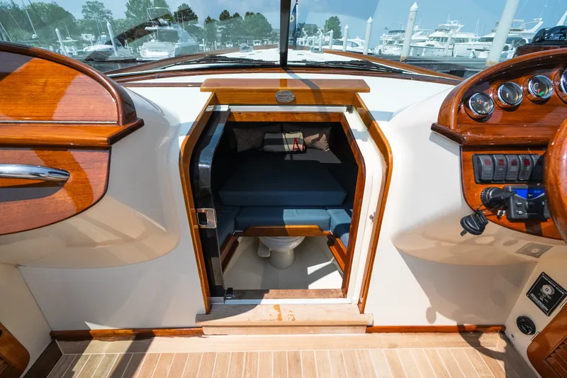 Slide: The Image of 2008 Hinckley Talaria 29R cabin interior with wooden dashboard and nautical controls. - 32