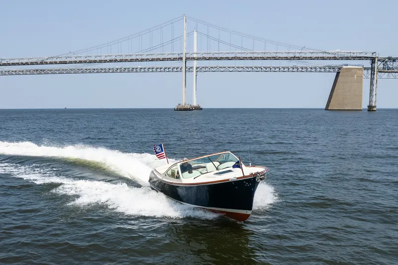 Slide: The Image of 2008 Hinckley Talaria 29R cruising under a large bridge on open water. - 4