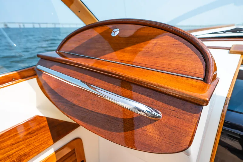 Slide: The Image of Polished wood dashboard detail on 2008 Hinckley Talaria 29R boat, with ocean background. - 29
