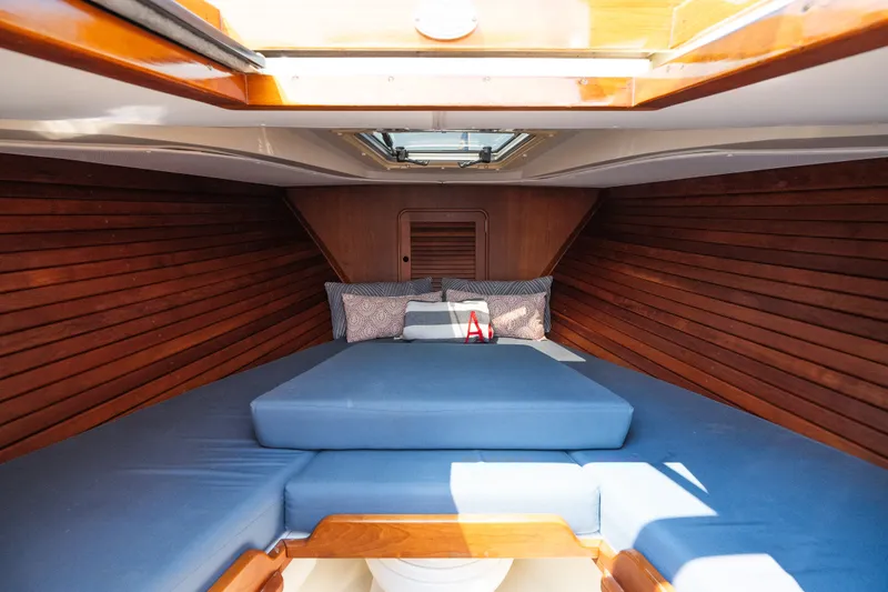 Slide: The Image of Interior cabin of 2008 Hinckley Talaria 29R with blue cushions and wooden paneling. - 33
