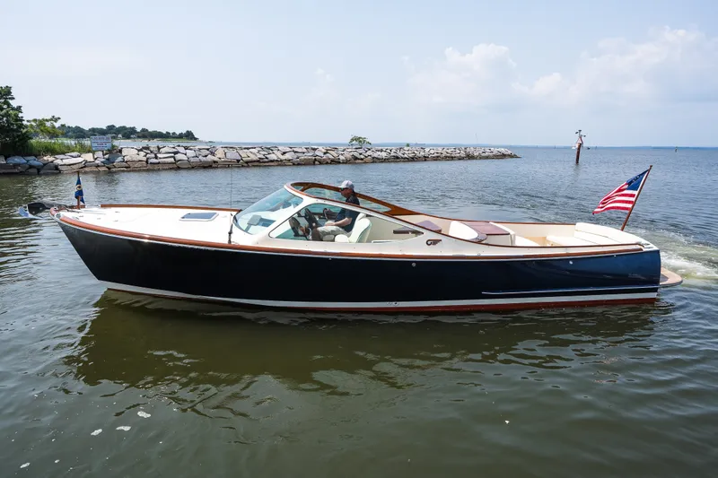 Slide: The Image of 2008 Hinckley Talaria 29R boat cruising on calm waters with American flag. - 14