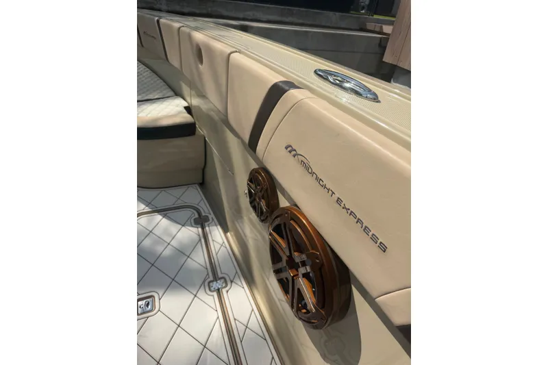 Slide: The Image of 2019 Midnight Express 43 Open boat interior with beige seating and stylish speaker design. - 6