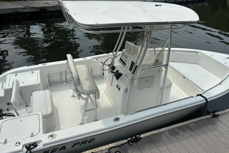 Slide: The Image of 2004 Sea Pro 206 Center Console boat docked, featuring spacious seating and steering console. - 8
