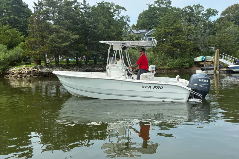 Slide: The Image of 2004 Sea Pro 206 Center Console boat on calm water with lush greenery background. - 5