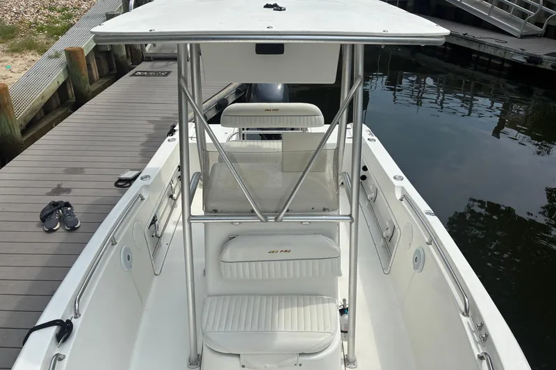 Slide: The Image of 2004 Sea Pro 206 Center Console boat docked, featuring white seating and a sturdy T-top. - 9