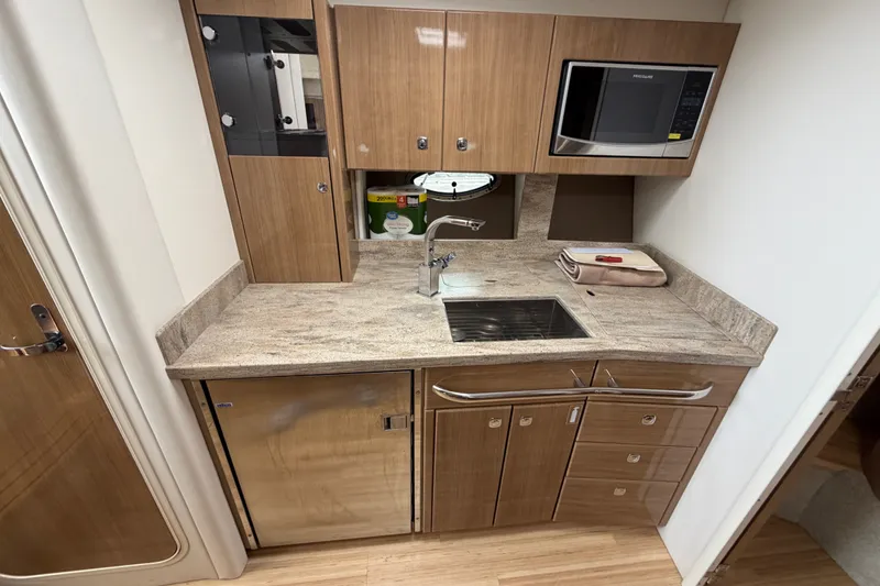 Slide: The Image of 2016 Formula 37 Performance Cruiser kitchen with wood cabinetry, sink, and microwave. - 19