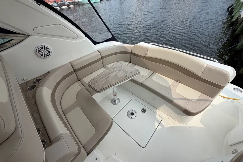 Slide: The Image of 2016 Formula 37 Performance Cruiser interior with beige seating and table, docked by water. - 8