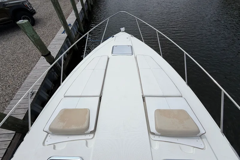 Slide: The Image of 2016 Formula 37 Performance Cruiser bow view with cushioned seating, docked by wooden posts. - 40