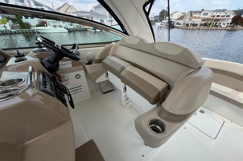 Slide: The Image of 2016 Formula 37 Performance Cruiser helm with beige seating and waterfront view. - 12