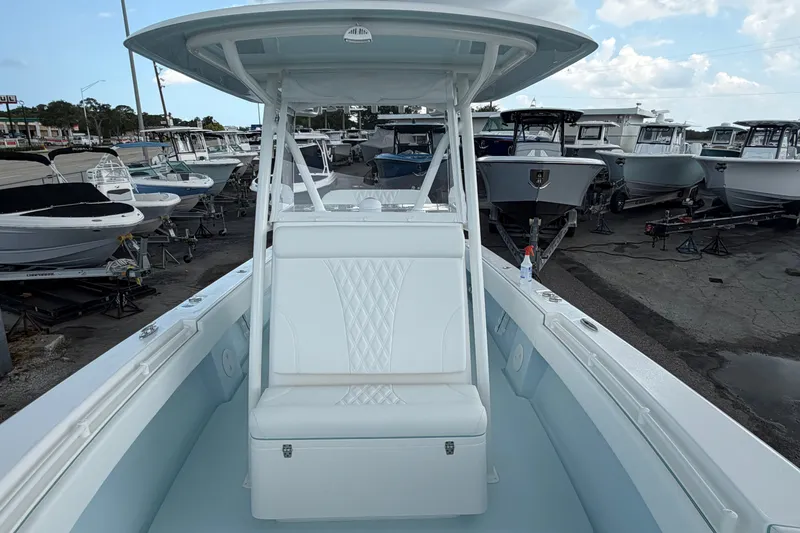 Slide: The Image of 2027 Contender 30 ST boat in a marina, surrounded by other vessels under a cloudy sky. - 29