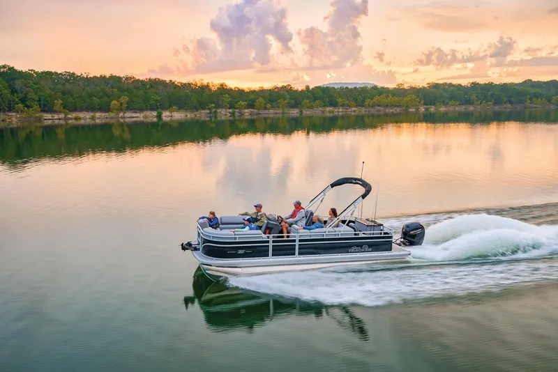 Slide: The Image of Manufacturer Provided Image: 2026 Sun Tracker SportFish 22 DLX pontoon boat cruising on a serene lake at sunset. - 69