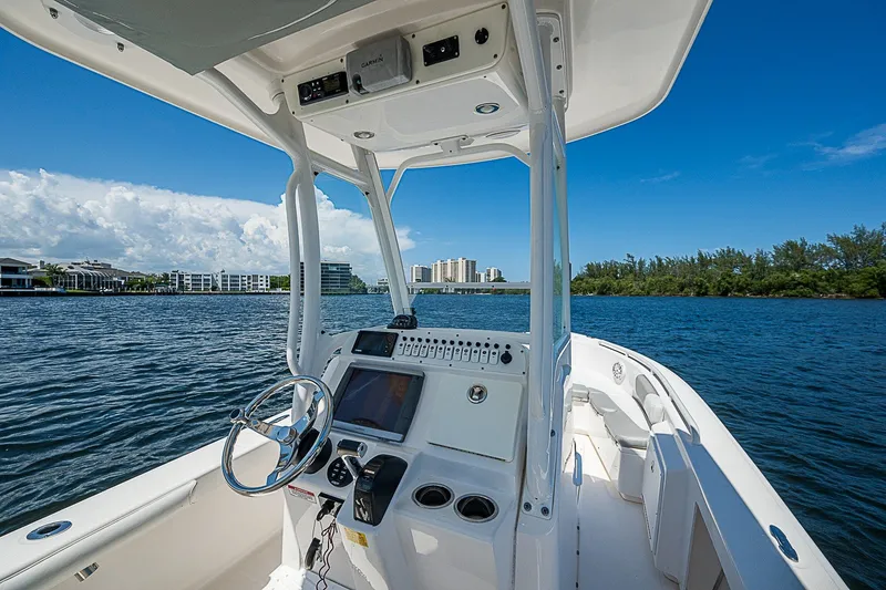 Slide: The Image of 2012 Everglades 243 Center Console boat on calm water, clear sky, cityscape background. - 18