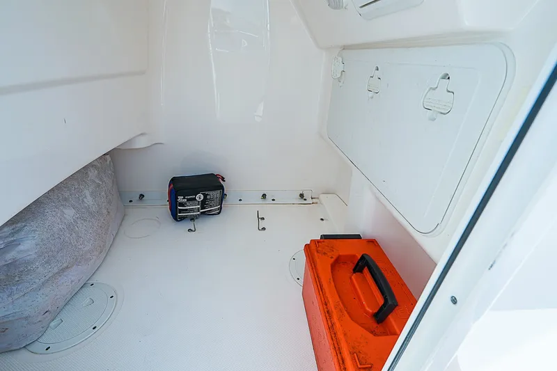 Slide: The Image of Interior storage of 2012 Everglades 243 Center Console boat with orange toolbox. - 22