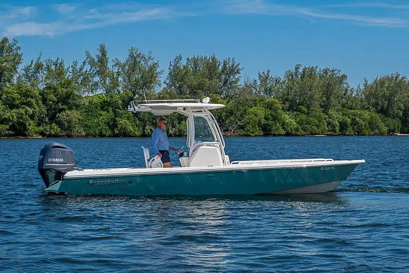 Slide: The Image of 2012 Everglades 243 Center Console boat on water, with lush greenery in the background. - 32