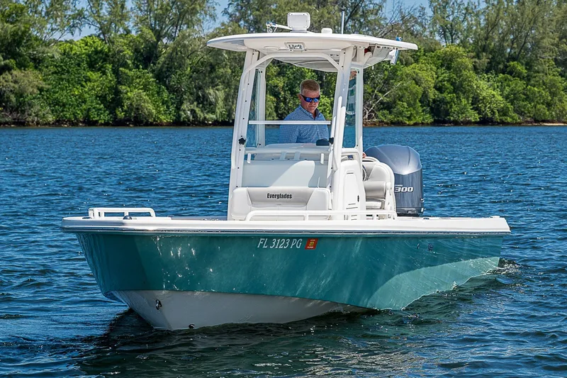 Slide: The Image of 2012 Everglades 243 Center Console boat cruising on a serene lake with lush greenery. - 27